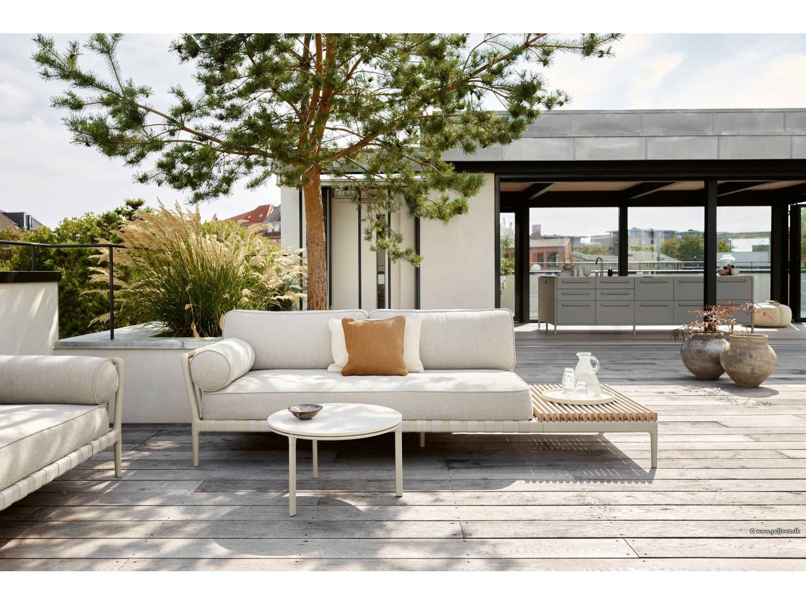 Das Sofa «Vipp 720» trotzt mit speziellen Outdoor-Materialien jeglichen Wetterbedingungen. Auf dem Gestell aus Aluminium und Edelstahl liegen schnelltrocknende Polster und Kissen, der Bezug ist UV-resistent und waschbar. An den Arm- und Rückenlehnen fallen Details aus Rattan auf, die eine optische Verbindung zu den Gurten der Basis schaffen. VIPP.