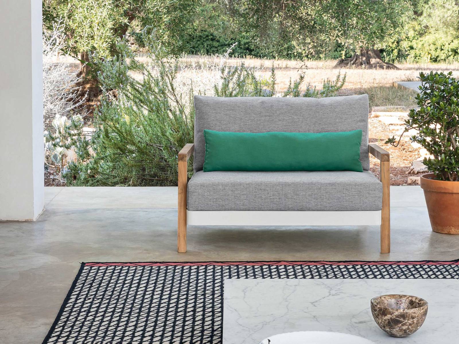 Die richtige Balance hat Paola Navone für ihre neueste Outdoor-Kollektion gesucht und gefunden. Für Win kombiniert die Italienerin einen weissen Aluminiumrahmen mit Armlehnen aus Naturteak. Streng gepolsterte Sitz- und Lehnenkissen unterstreichen das auffällig  reduzierte Design, welches als Sessel oder Sofa zu haben ist. GERVASONI.