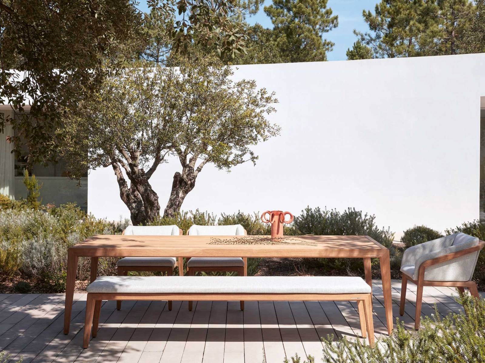 «Sunrise» heisst das Outdoor-Ensemble von Matthew Townsend, bei dem hochwertiges Teakholz in eleganten Linien und Rundungen mit weich gepolsterten Sitz- und Rückenkissen eine Liaison eingeht. MANUTTI.