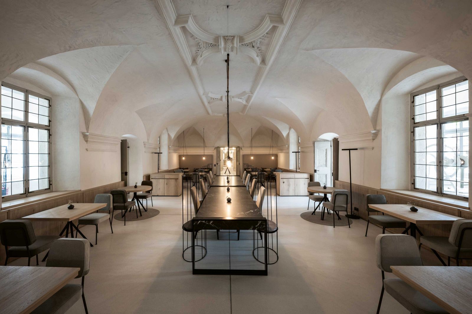 Fast monumental wirkt der grosszügige Frühstückraum mit seinem Gewölbe in der Mitte des Erdgeschosses. Rund um die lange Tafel sind zusätzliche Einzeltische angeordnet.